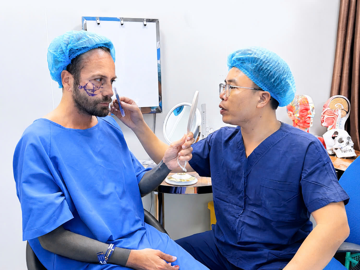 Dr. Mark Nguyen marks and outlines the areas on the client's face requiring surgery. 