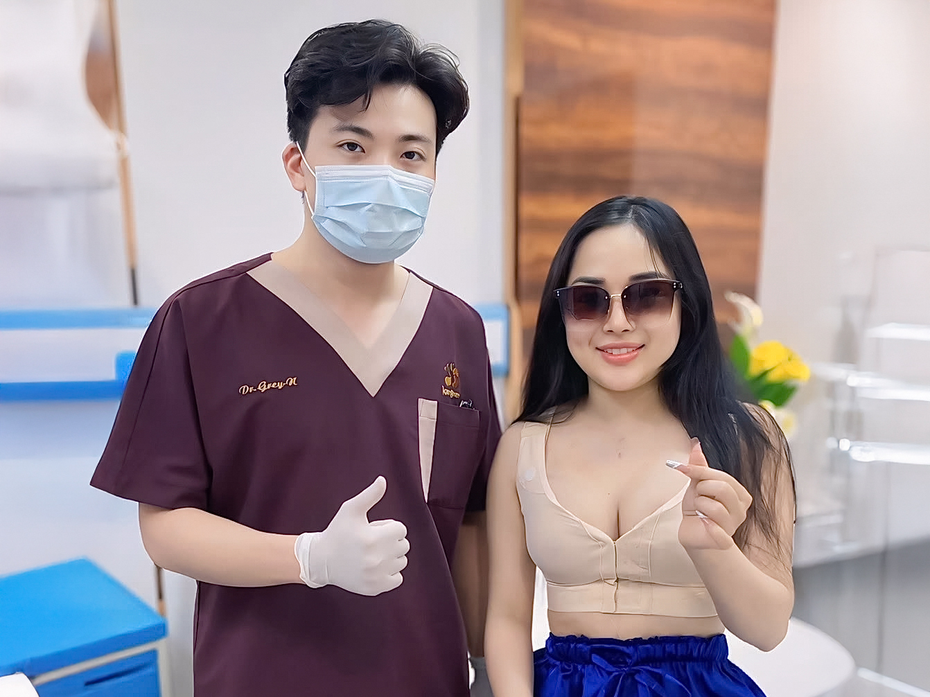 A cosmetic surgery doctor posing with a patient during a post-operative follow-up visit, illustrating recovery monitoring and ongoing care after surgery.